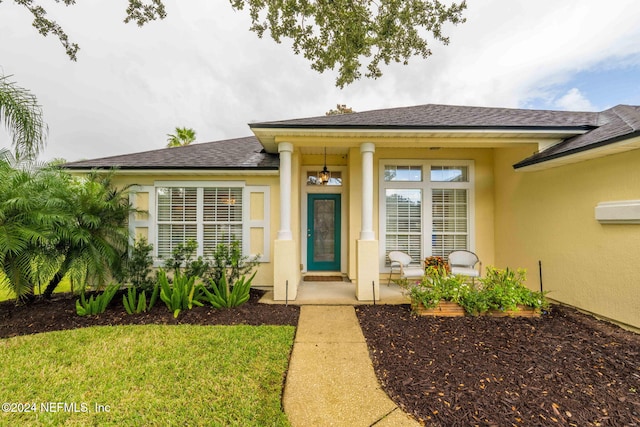 entrance to property with a yard and covered porch