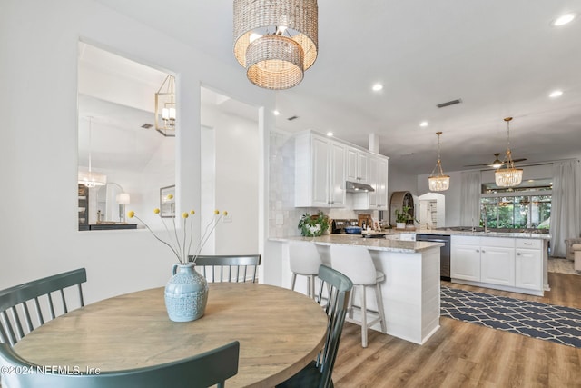 dining room featuring an inviting chandelier, sink, and light wood-type flooring