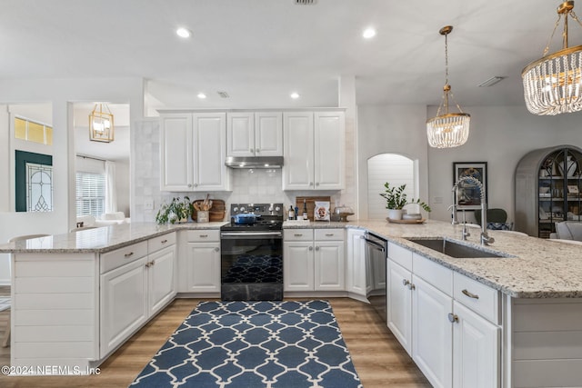 kitchen with hanging light fixtures, white cabinetry, stainless steel dishwasher, light wood-type flooring, and black electric range