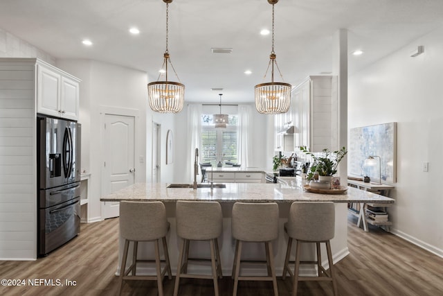 kitchen with stainless steel appliances, wood-type flooring, sink, and white cabinets