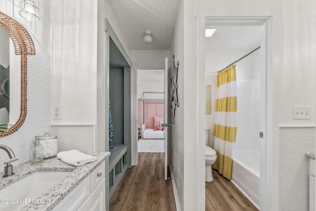 full bathroom with vanity, toilet, shower / bath combo with shower curtain, and wood-type flooring