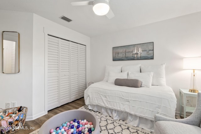 bedroom with a closet, ceiling fan, and dark hardwood / wood-style flooring