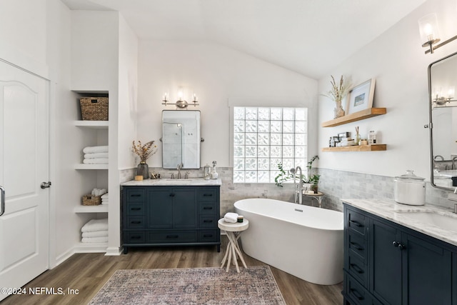 bathroom featuring vanity, lofted ceiling, a bathing tub, and hardwood / wood-style floors