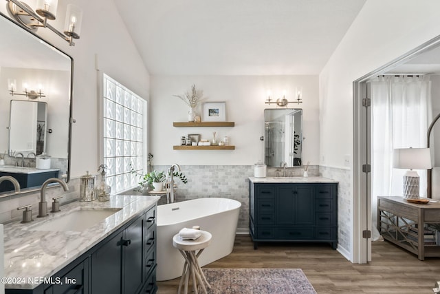 bathroom with separate shower and tub, tile walls, lofted ceiling, vanity, and hardwood / wood-style flooring