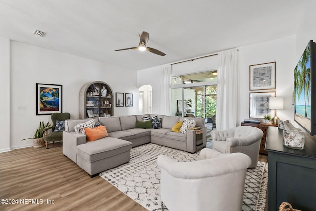 living room with light wood-type flooring and ceiling fan