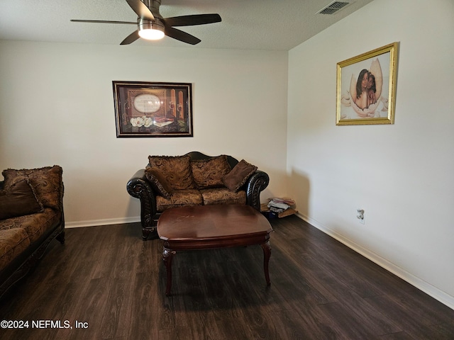 sitting room featuring dark wood-type flooring, ceiling fan, and a textured ceiling