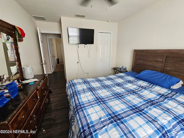 unfurnished bedroom featuring a closet, ceiling fan, a textured ceiling, and dark hardwood / wood-style flooring