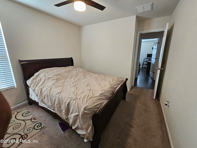 bedroom with dark carpet, a textured ceiling, and ceiling fan