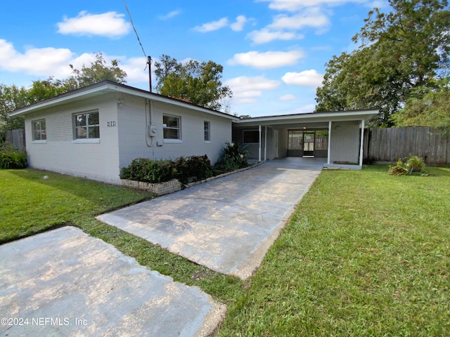 view of front of home with a front lawn and a carport