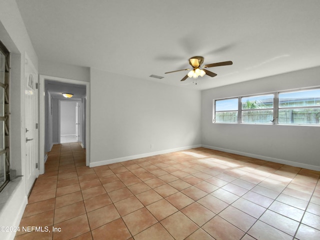 tiled empty room featuring ceiling fan