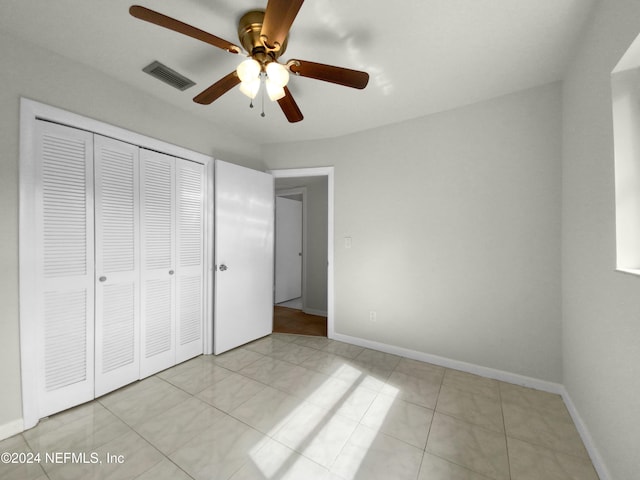 unfurnished bedroom featuring light tile patterned floors, a closet, and ceiling fan