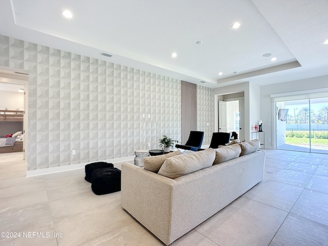 living room featuring tile walls and a tray ceiling