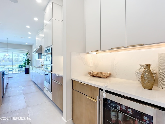 kitchen with white cabinetry, light tile patterned floors, beverage cooler, and decorative light fixtures