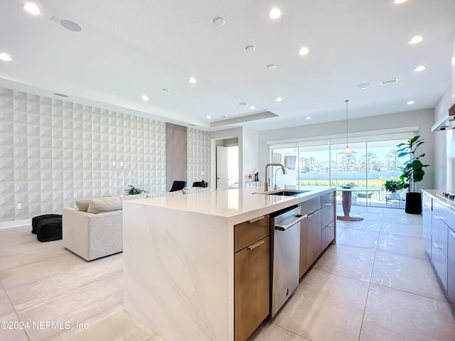 kitchen with a spacious island, sink, tile walls, dishwasher, and hanging light fixtures