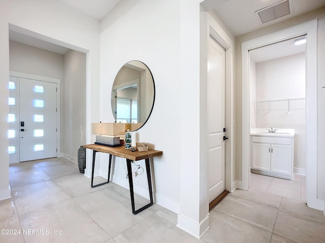 tiled entryway featuring sink and plenty of natural light