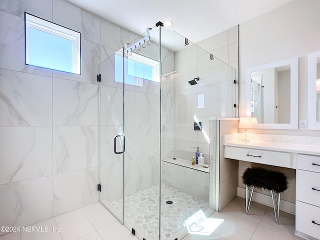 bathroom featuring tile patterned floors, a shower with door, and vanity