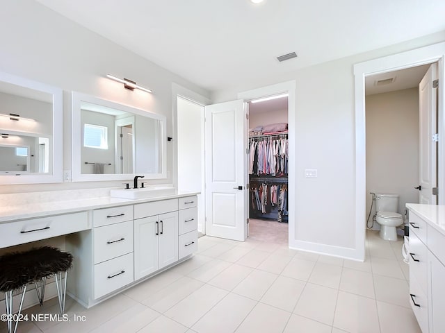 bathroom featuring tile patterned flooring, vanity, and toilet