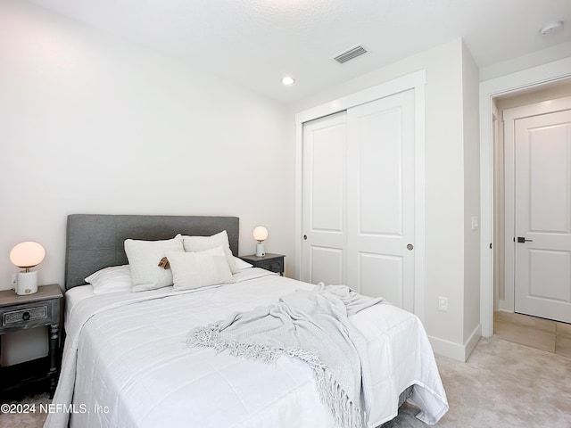 bedroom with light carpet and a closet