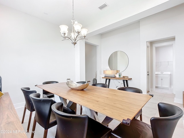 tiled dining room featuring a notable chandelier