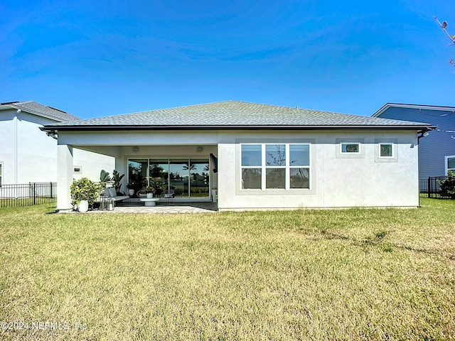 back of property with a lawn and a patio area