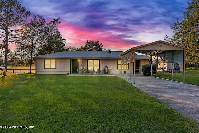 view of front of home featuring a carport and a lawn