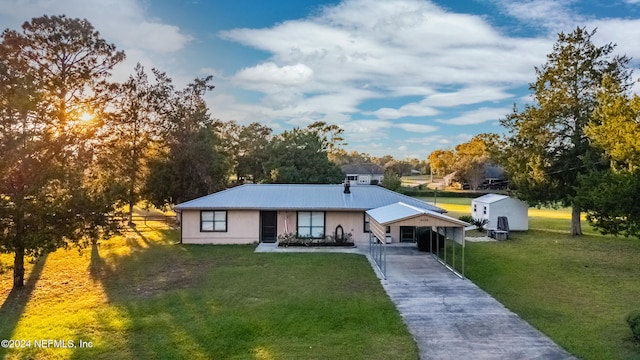 view of front of property with a carport, a storage shed, and a front yard