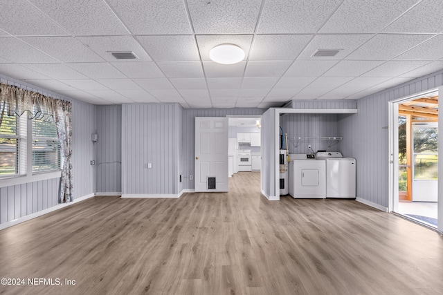 unfurnished living room featuring independent washer and dryer, a paneled ceiling, light hardwood / wood-style flooring, and plenty of natural light