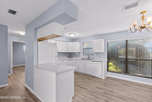 kitchen featuring white appliances, hanging light fixtures, light hardwood / wood-style flooring, a textured ceiling, and white cabinetry