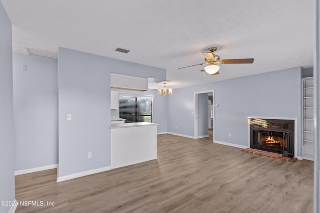 unfurnished living room with a brick fireplace, light hardwood / wood-style flooring, and ceiling fan