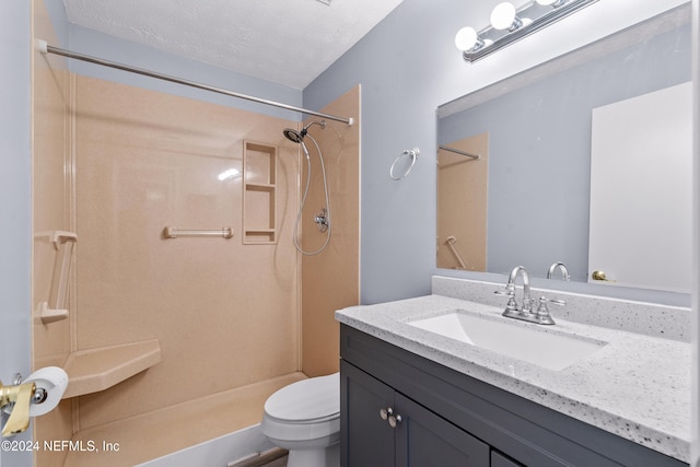 bathroom featuring a shower, vanity, a textured ceiling, and toilet