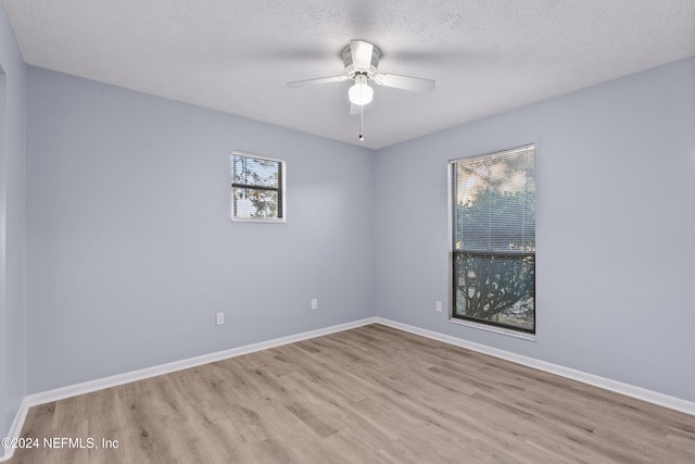 unfurnished room featuring ceiling fan, light hardwood / wood-style flooring, and a textured ceiling