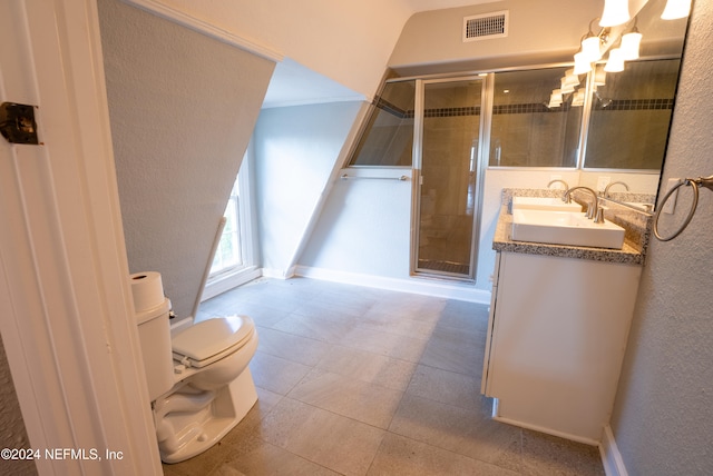 bathroom featuring vanity, toilet, and a shower with shower door