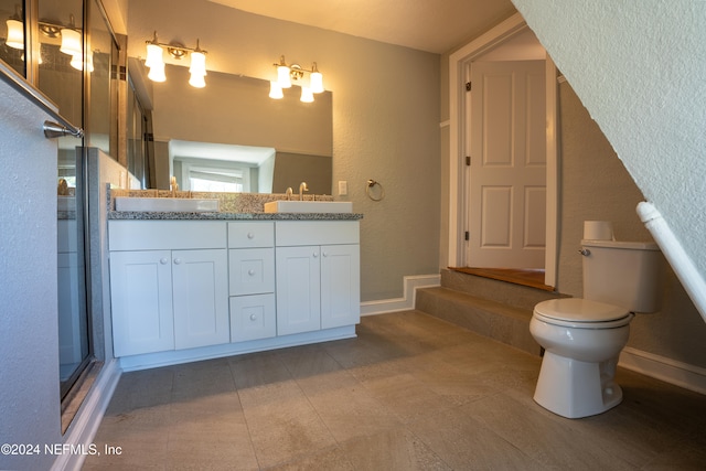 bathroom with vanity, tile patterned floors, toilet, and a shower with shower door