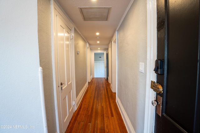 hallway with dark hardwood / wood-style floors and ornamental molding