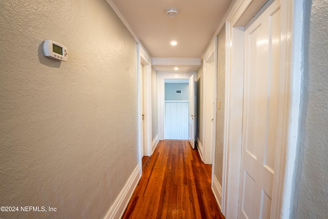 corridor with dark hardwood / wood-style flooring