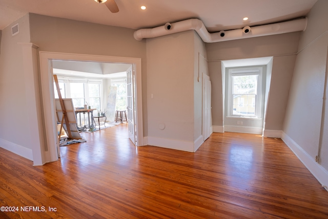 foyer entrance with a wealth of natural light, ceiling fan, and light hardwood / wood-style flooring