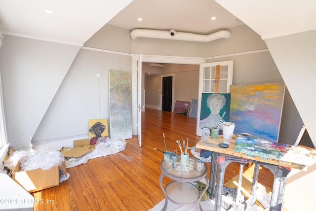 interior space with wood-type flooring and crown molding