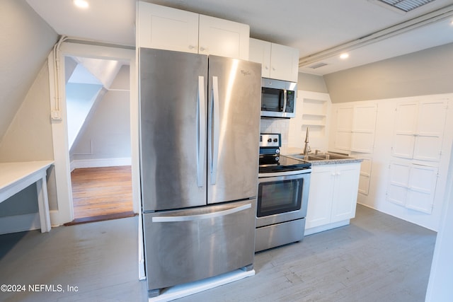 kitchen featuring stainless steel appliances, white cabinets, light hardwood / wood-style flooring, and tasteful backsplash