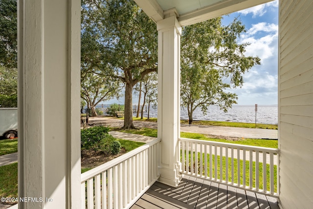 balcony featuring covered porch and a water view