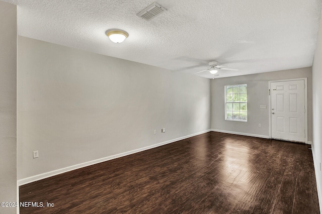 empty room featuring dark wood-type flooring, a textured ceiling, and ceiling fan