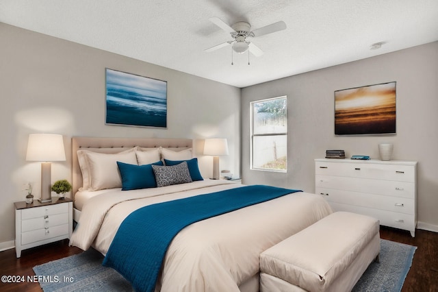 bedroom with dark wood-type flooring, ceiling fan, and a textured ceiling