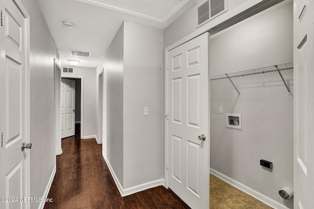 clothes washing area featuring dark wood-type flooring, hookup for a washing machine, and a textured ceiling