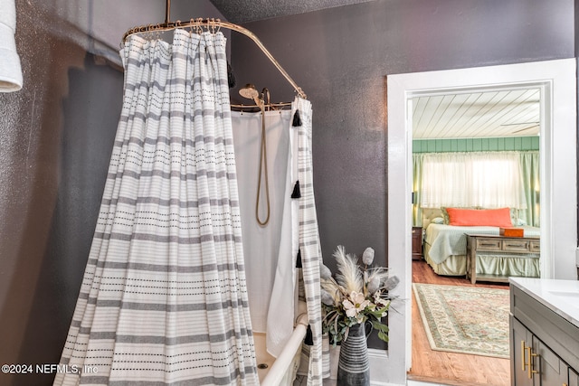 bathroom with vanity, hardwood / wood-style floors, and shower / bath combination with curtain