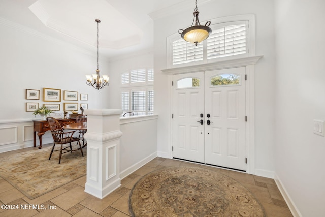 foyer with a chandelier and ornamental molding