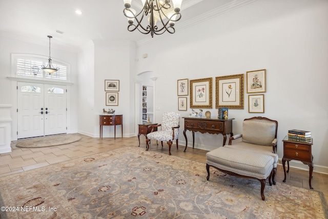 entryway with an inviting chandelier, tile patterned floors, ornamental molding, and a towering ceiling