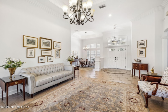 living room featuring a towering ceiling, an inviting chandelier, and ornamental molding