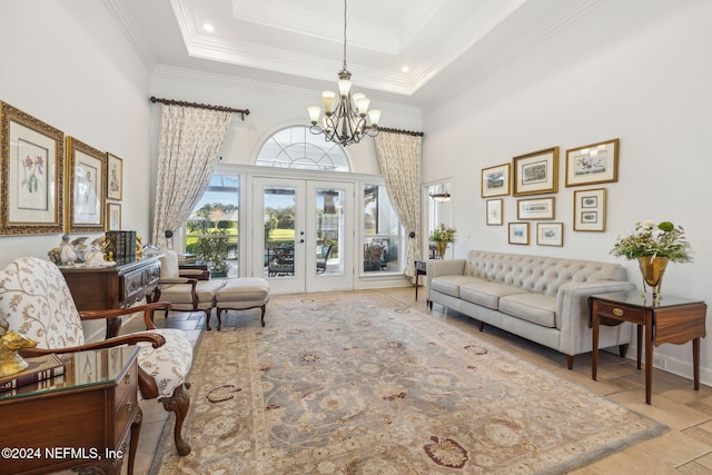 living room with a chandelier, french doors, ornamental molding, and a towering ceiling