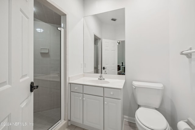 bathroom featuring tile patterned flooring, an enclosed shower, vanity, and toilet