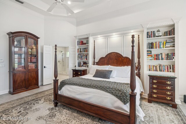 tiled bedroom featuring a high ceiling, ceiling fan, connected bathroom, and ornamental molding