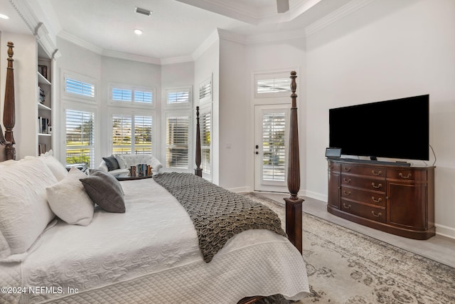 bedroom with a towering ceiling, multiple windows, and ornamental molding